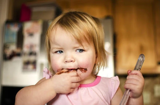 Little girl enjoying Nutella